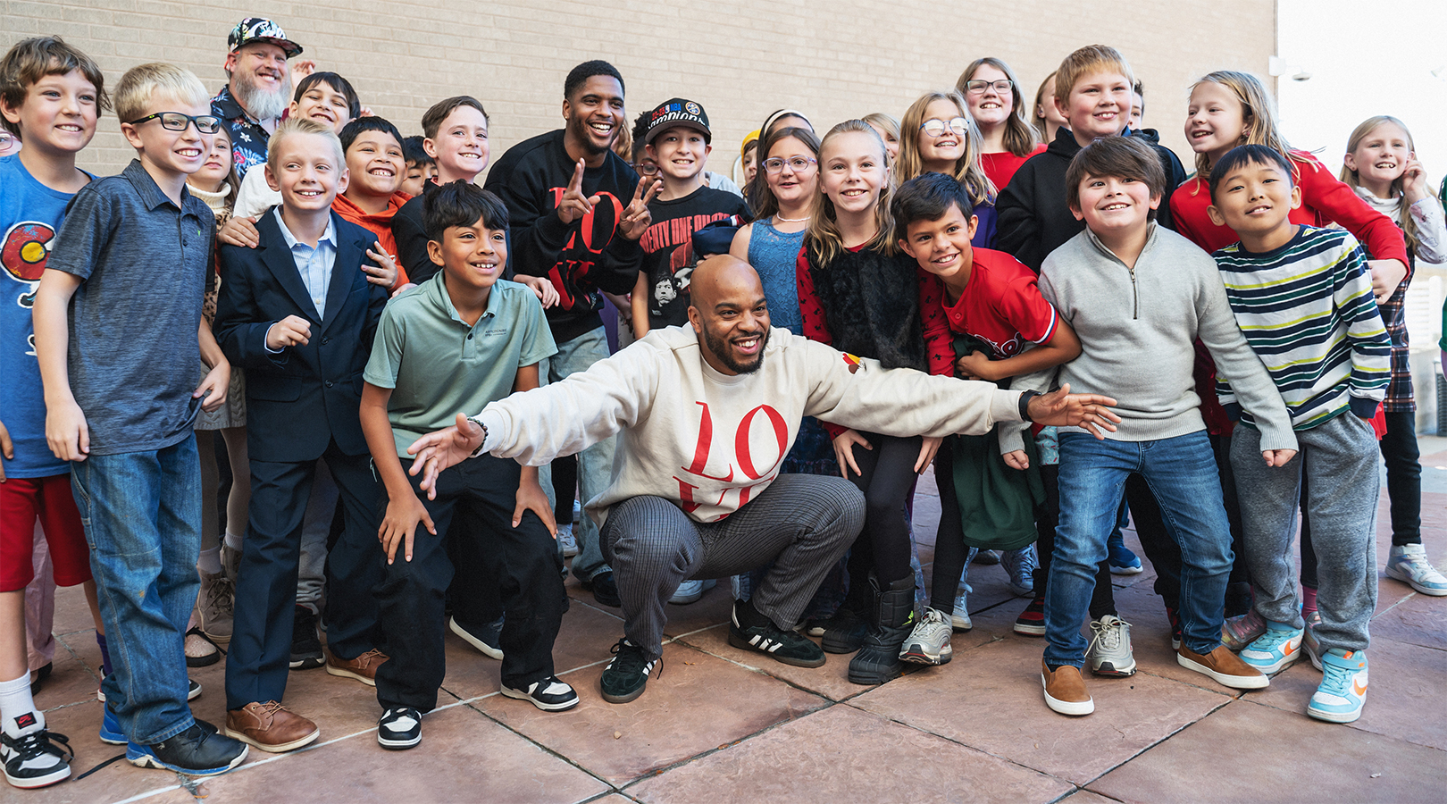 Wayne Watts and a group of students pose for a picture outside Boettcher Concert Hall after a Youth Concert.