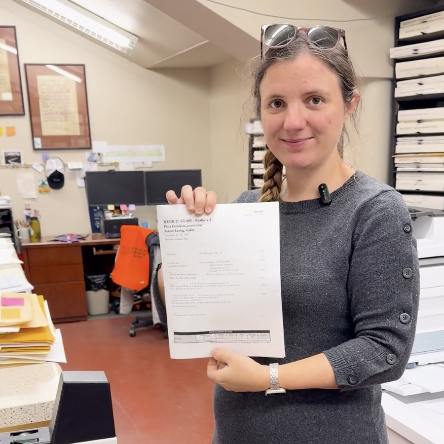 Assistant Librarian Aspen McArthur holding a score in the Library